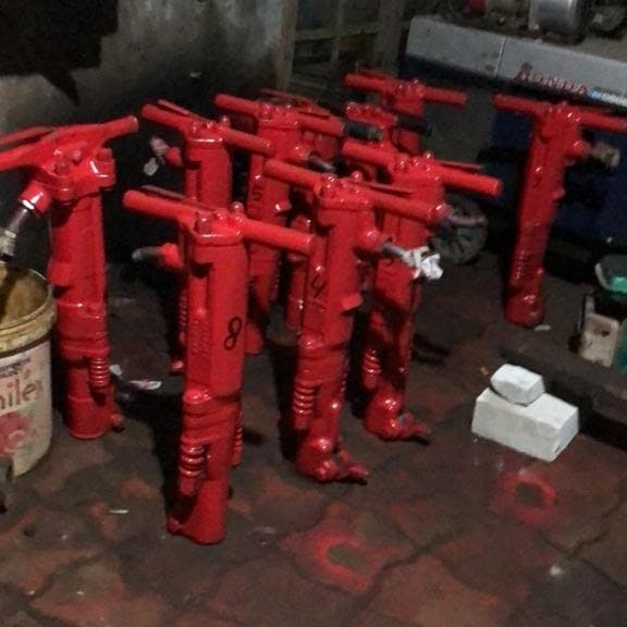 Pekerja menggunakan jack hammer listrik untuk membobok jalan